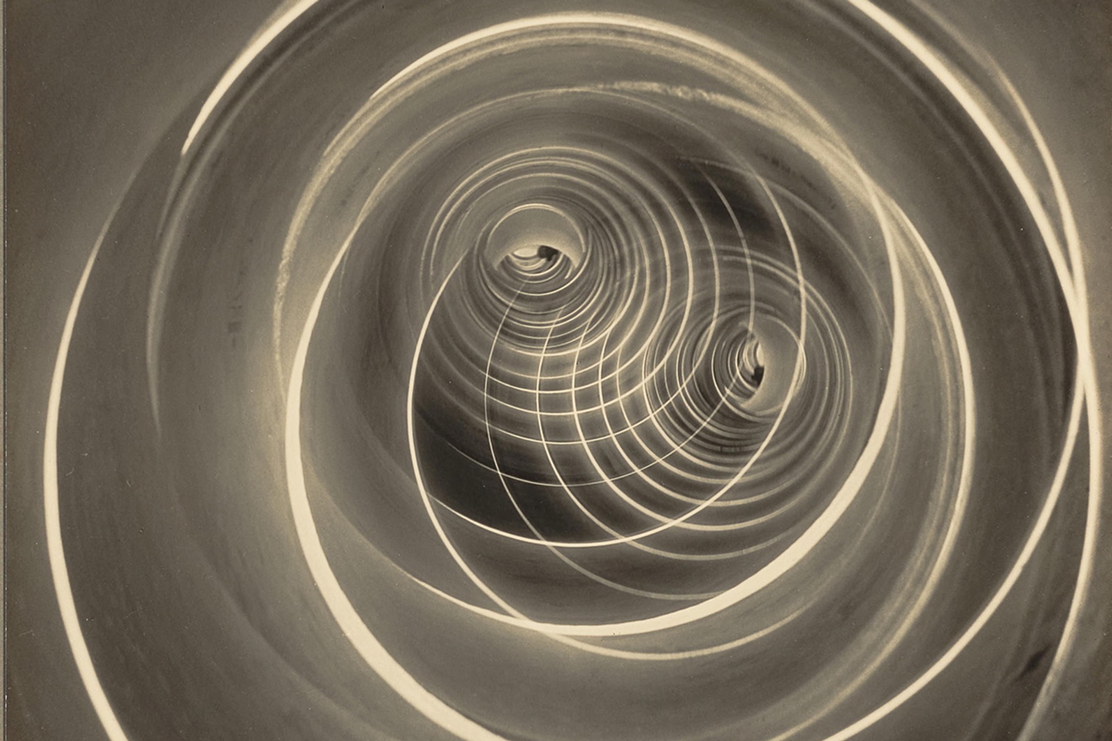 Black and white photo of a spiral pattern resembling a spiral staircase or vortex with concentric circular rings.